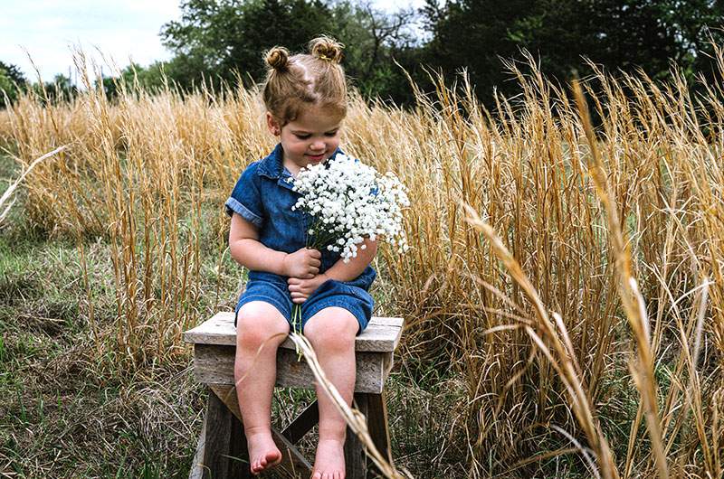 Little girl in a denim romper in a wheat field — McKinney newborn and family photography by BK Bennett