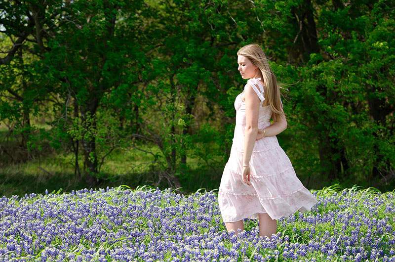 Senior in a blush dress among Texas bluebonnets — Rockwall senior photographer BK Bennett